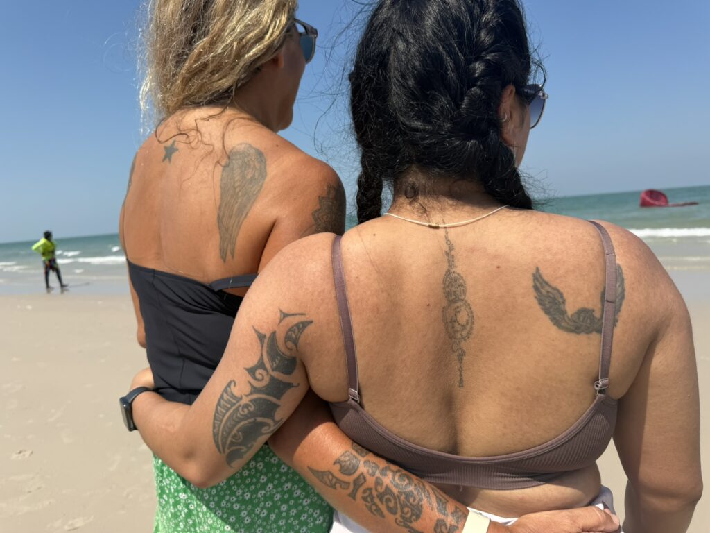 two women with wing tattoos on a beach in Hua Hin Thailand